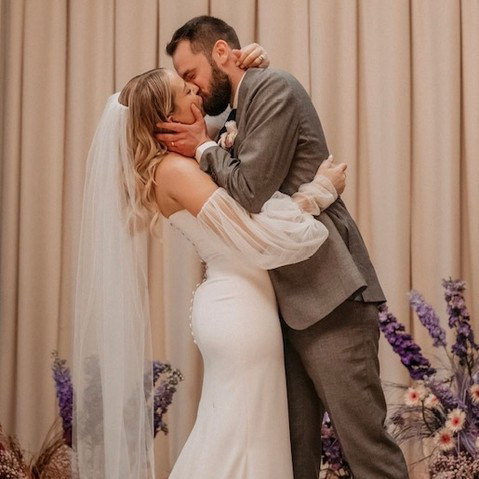 Mo and Matt sharing their first kiss at their wedding.