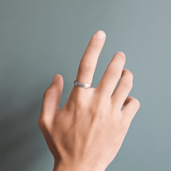 Model wearing Cornice Band / Five Tiers on index finger