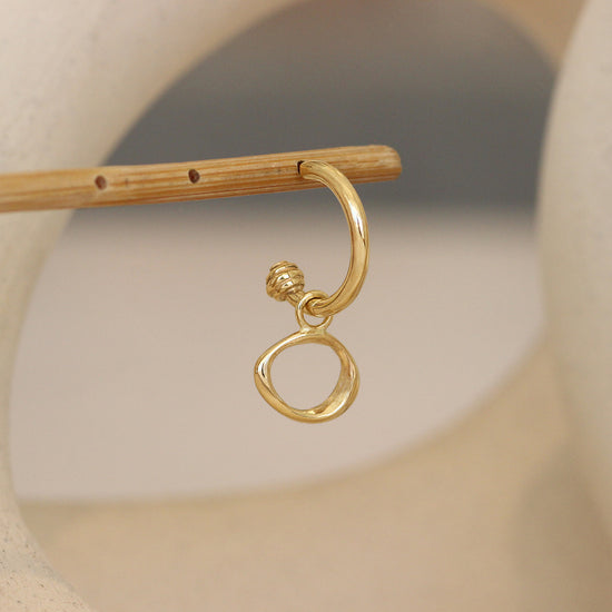 Amorphous Charm / Small Circle on a Cornice Hoop making an earring.