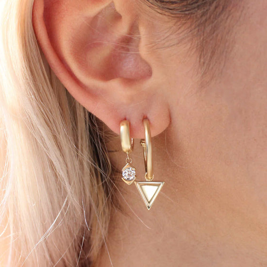 Model wearing Horus Charm / Lab Round Diamond on a hoop earring alongside another charm and earring configuration