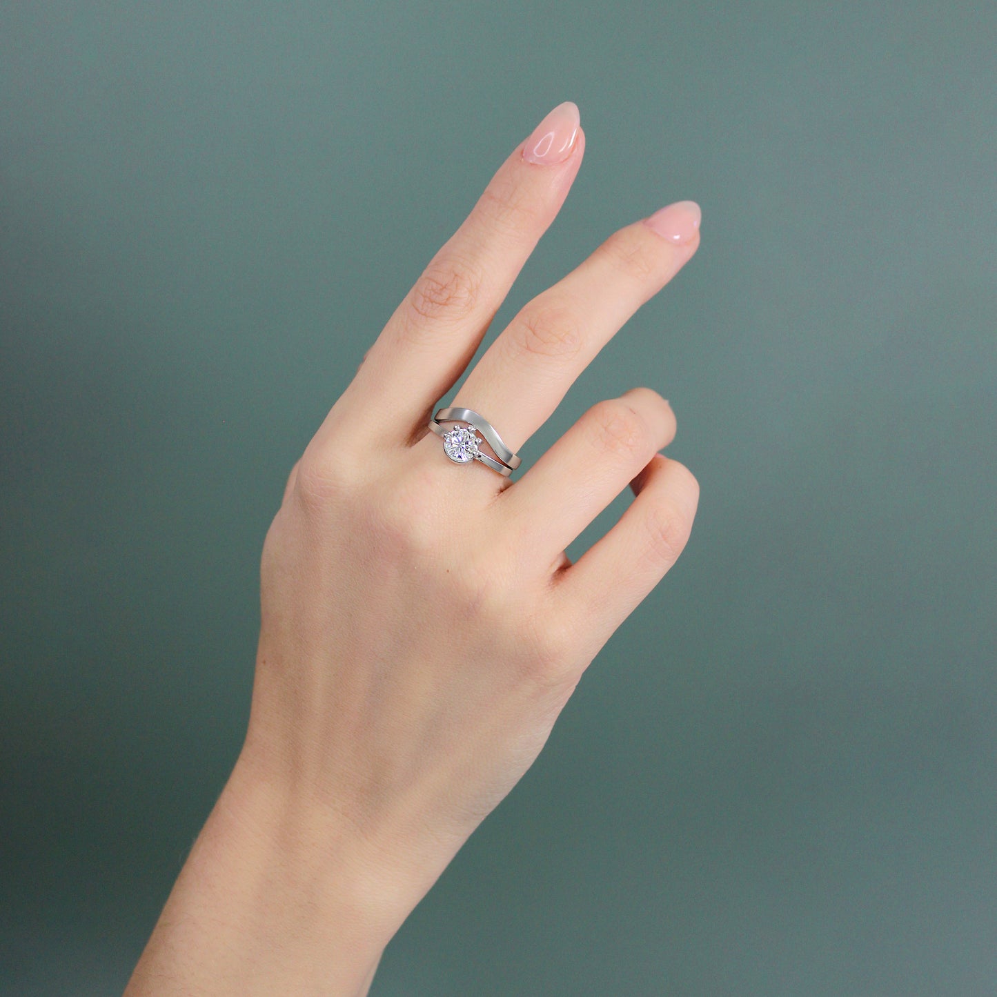 Model wearing Curve Flat Band / Wide with Miro Engagement ring on middle finger