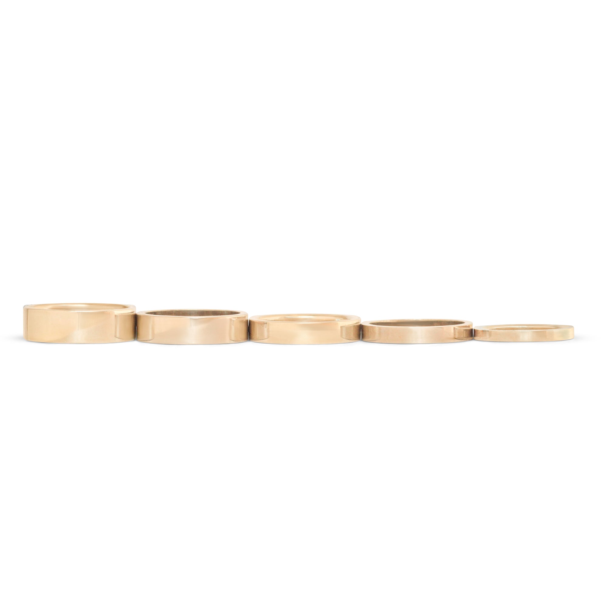 Stacked view of Flat Bands lined up together in various widths in 14k yelow gold
