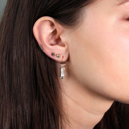 Model wearing Step Charm / Rectangle White Mother of Pearl with other Goldpoint stud earrings