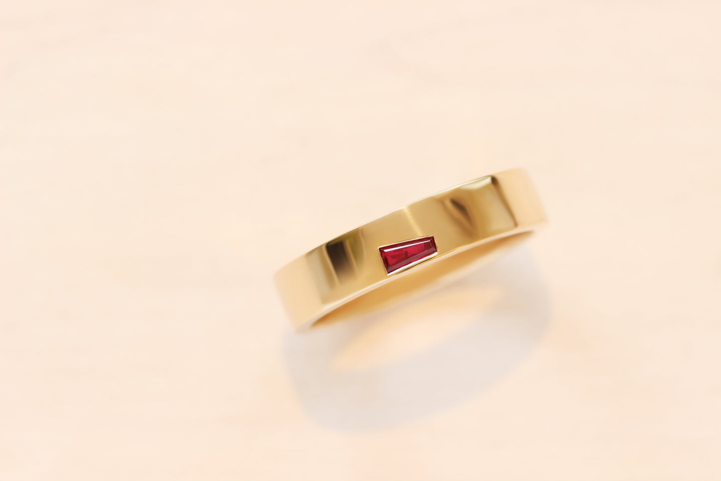 Flush set baguette ruby in yellow gold, based on our Horizon Collection band