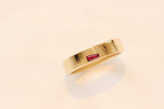 Flush set baguette ruby in yellow gold, based on our Horizon Collection band