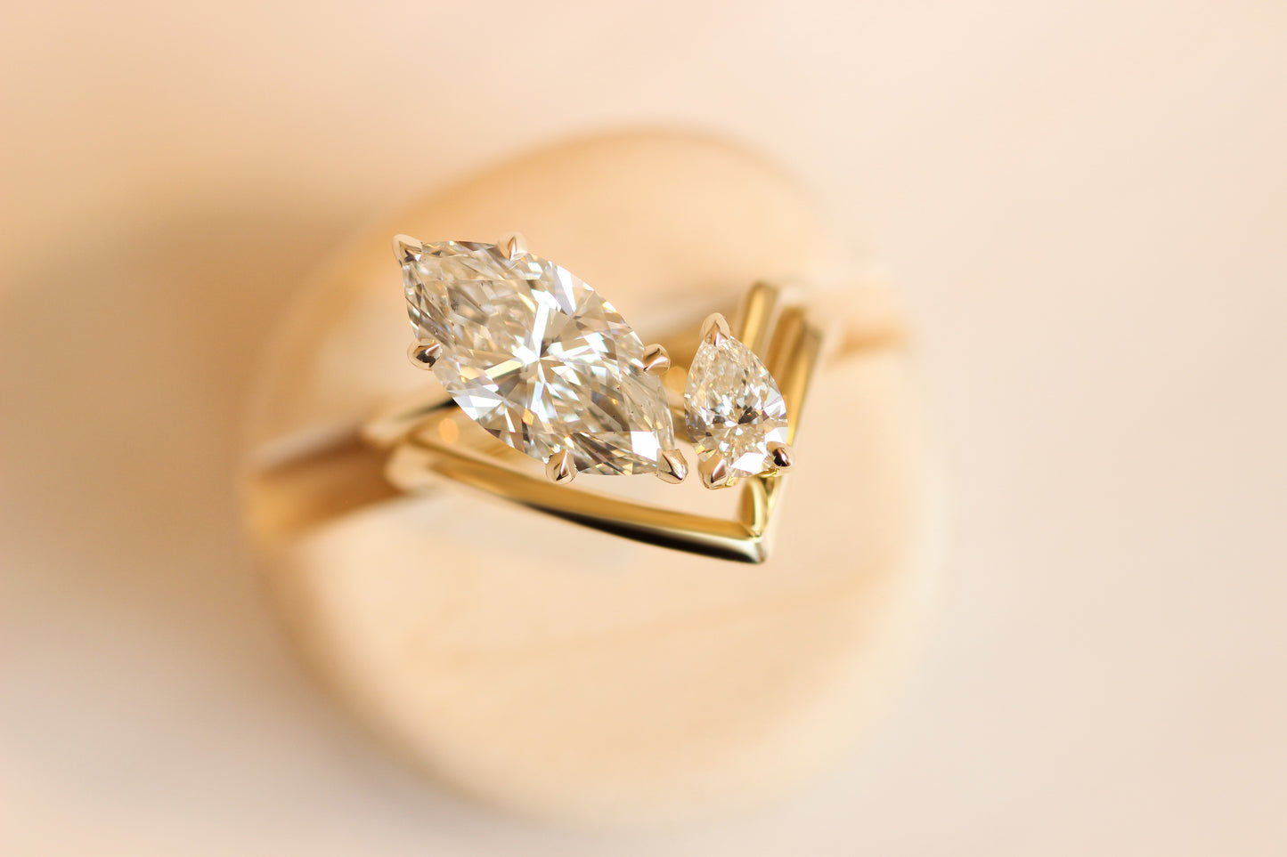 Angled two stone ring featuring marquise and pear white diamonds