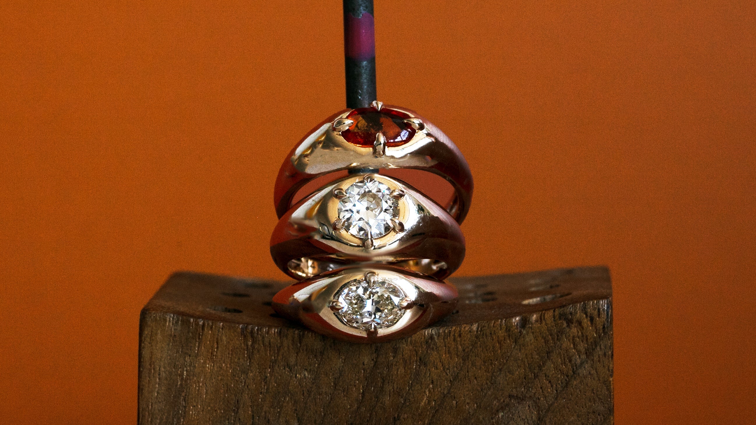 Lifestyle front view of Leonard 4 Ring Marquise Diamond 1.02ct on a ceramic with a blurred orange backdrop