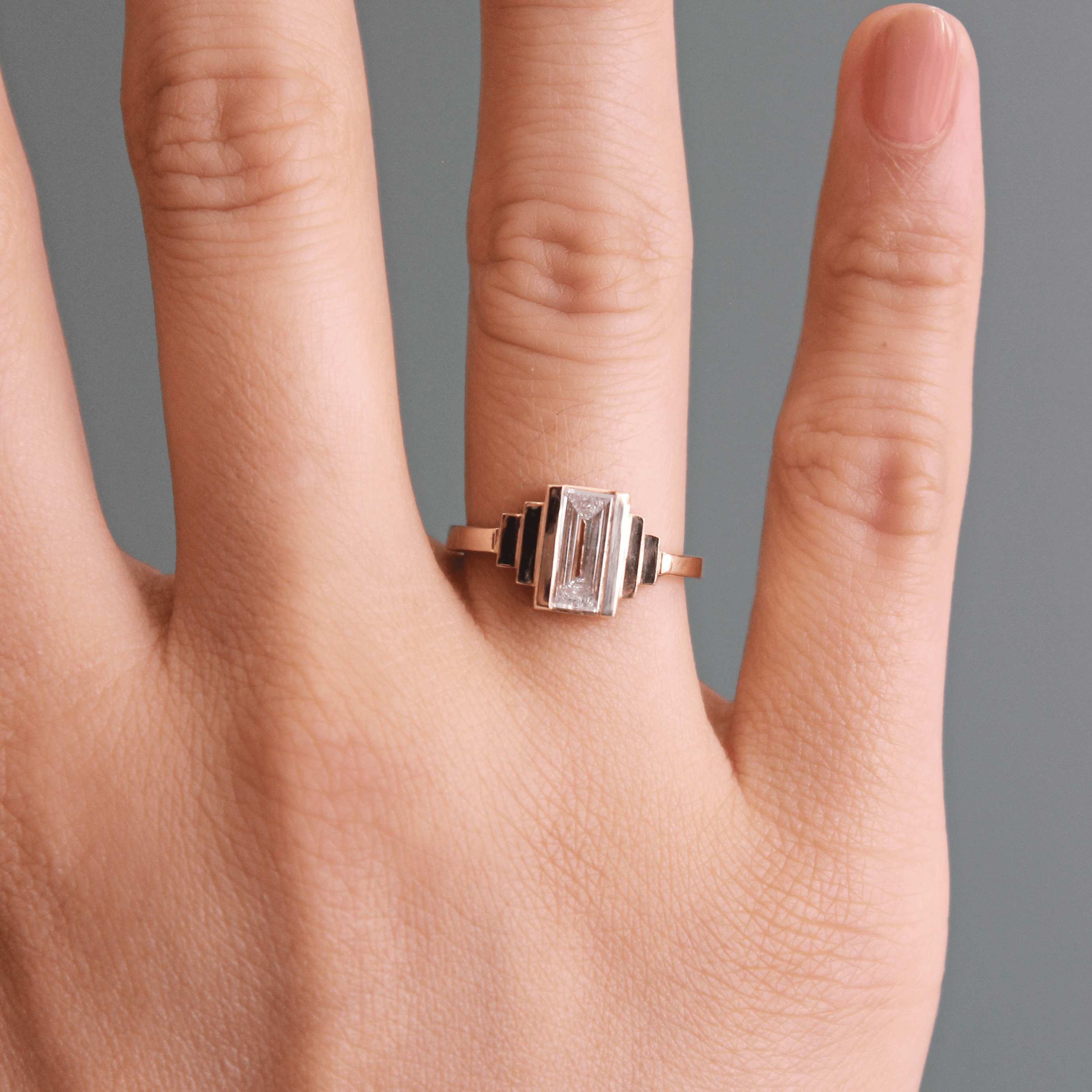 Model wears Kent Ring Baguette Lab Diamond 1.2ct by Goldpoint Jewelry on ring finger with pale blue background