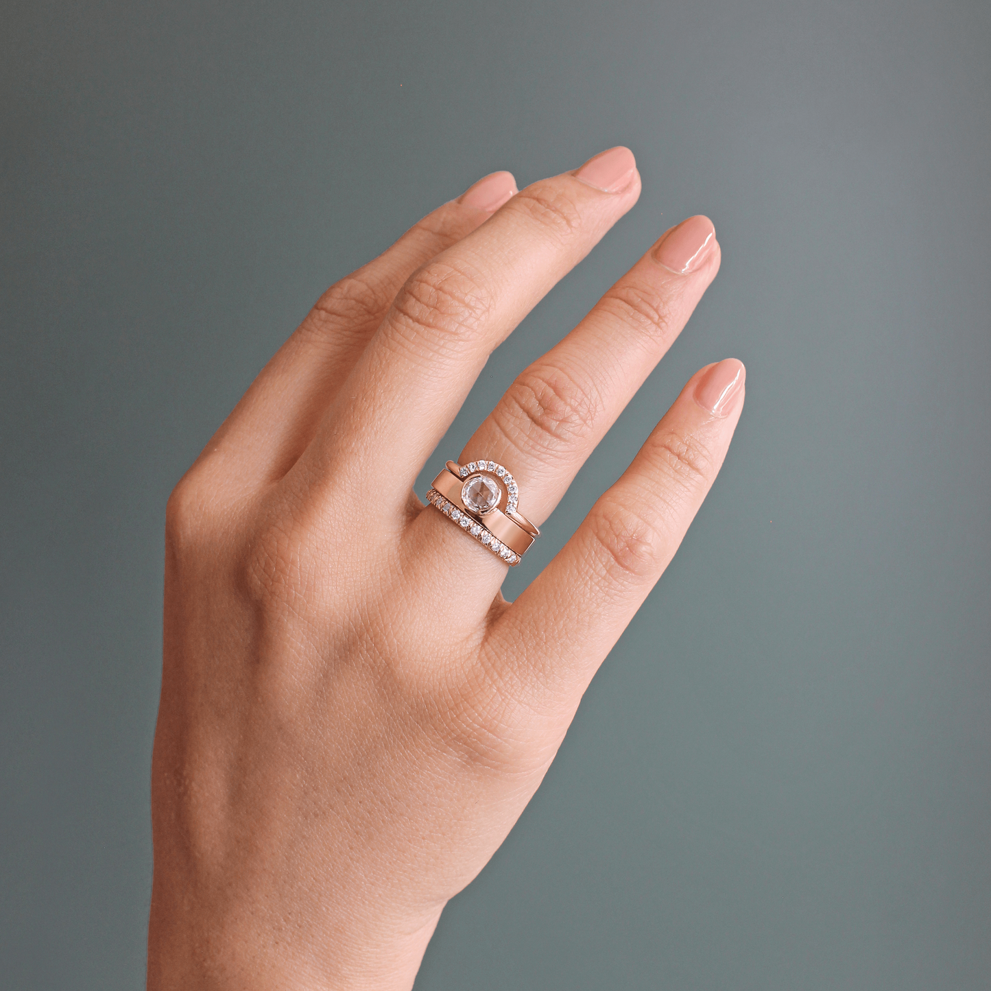 Model wearing a stack of matrimony pieces on ring finger featuring Dome Band / French Pave Diamonds