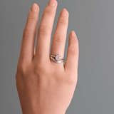 Model wears Flat Wide Band Deep Curve in platinum stacked with engagement ring on ring finger