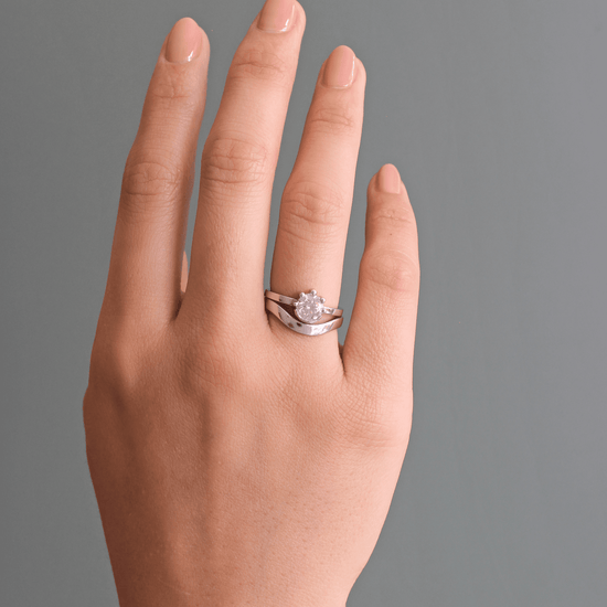 Model wearing Curve Flat Band / Wide on ring finger with Miro engagement ring