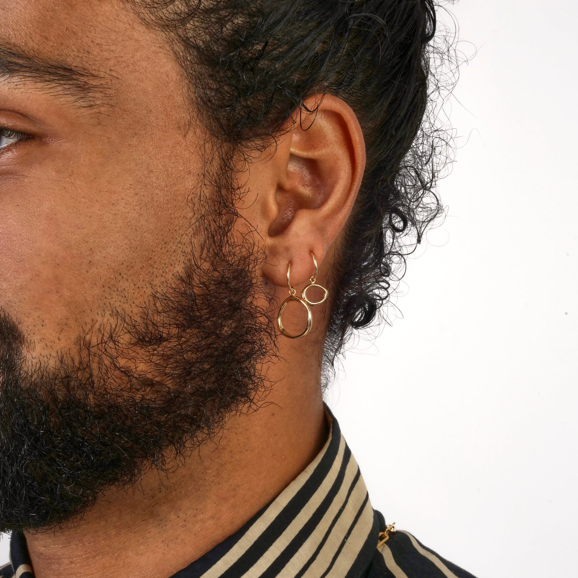 Model wears Amorphous Charm / Small Circle and Amorphous Charm / Large Circle on hoops by Goldpoint Jewelry on their ear