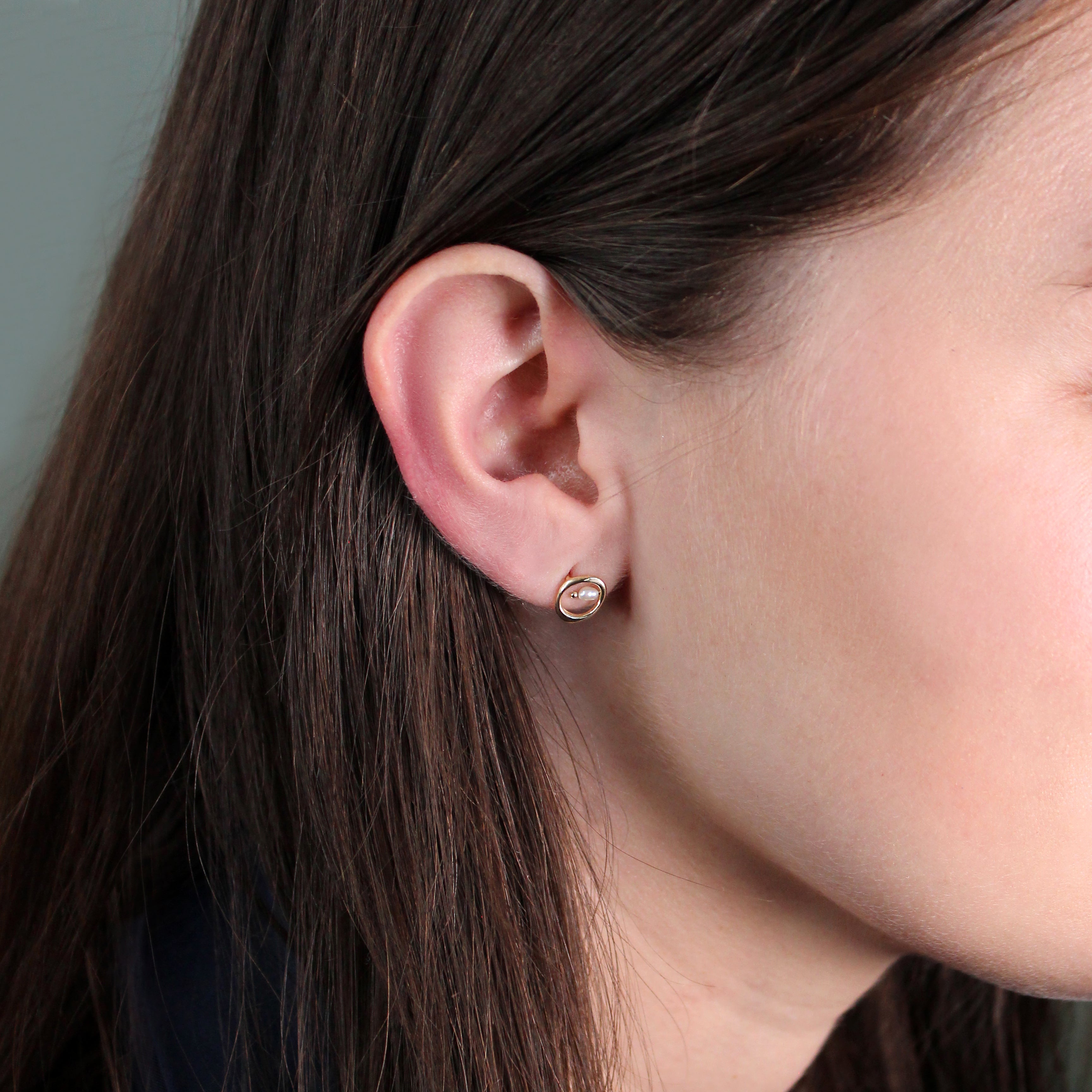 Model wears Amorphous Earring Bead Pearl Small Circle by Goldpoint Jewelry in ear