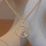 Lifestyle view of Amorphous Large Circle Bead Pearl Necklace / Cable Chain by Goldpoint Jewelry hanging with ceramics as a backdrop