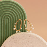 Lifestyle front view of Amorphous Pearl Bead Earring by Goldpoint Jewelry on decorative ceramic stands