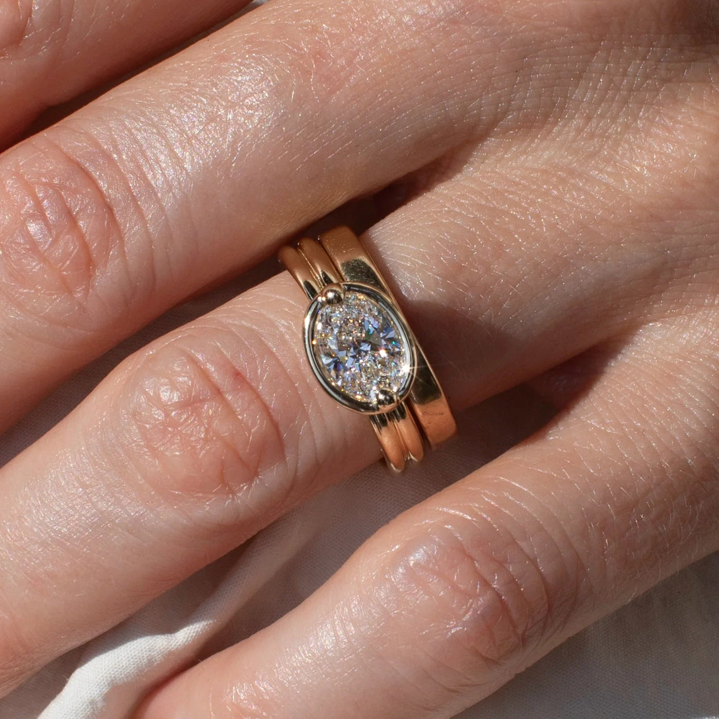 Model wears Bardot Ring / Oval Lab Diamond 1.06ct by Mon Pilar stacked with wedding band on finger