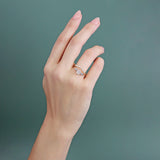 Model wears Flat Band Deep Curve Pave Round Lab Diamonds in 14k yellow gold stacked with an engagement ring