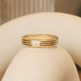 Lifestyle angled side view of Break of Day Ring / Half Moon Lab Diamond 0.25ct by Sandy Rubin on a ceramic with a blurred background