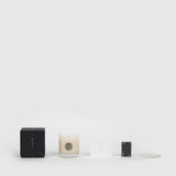 Lifestyle shot of Wood Cabin Scented Candle and the packaging components