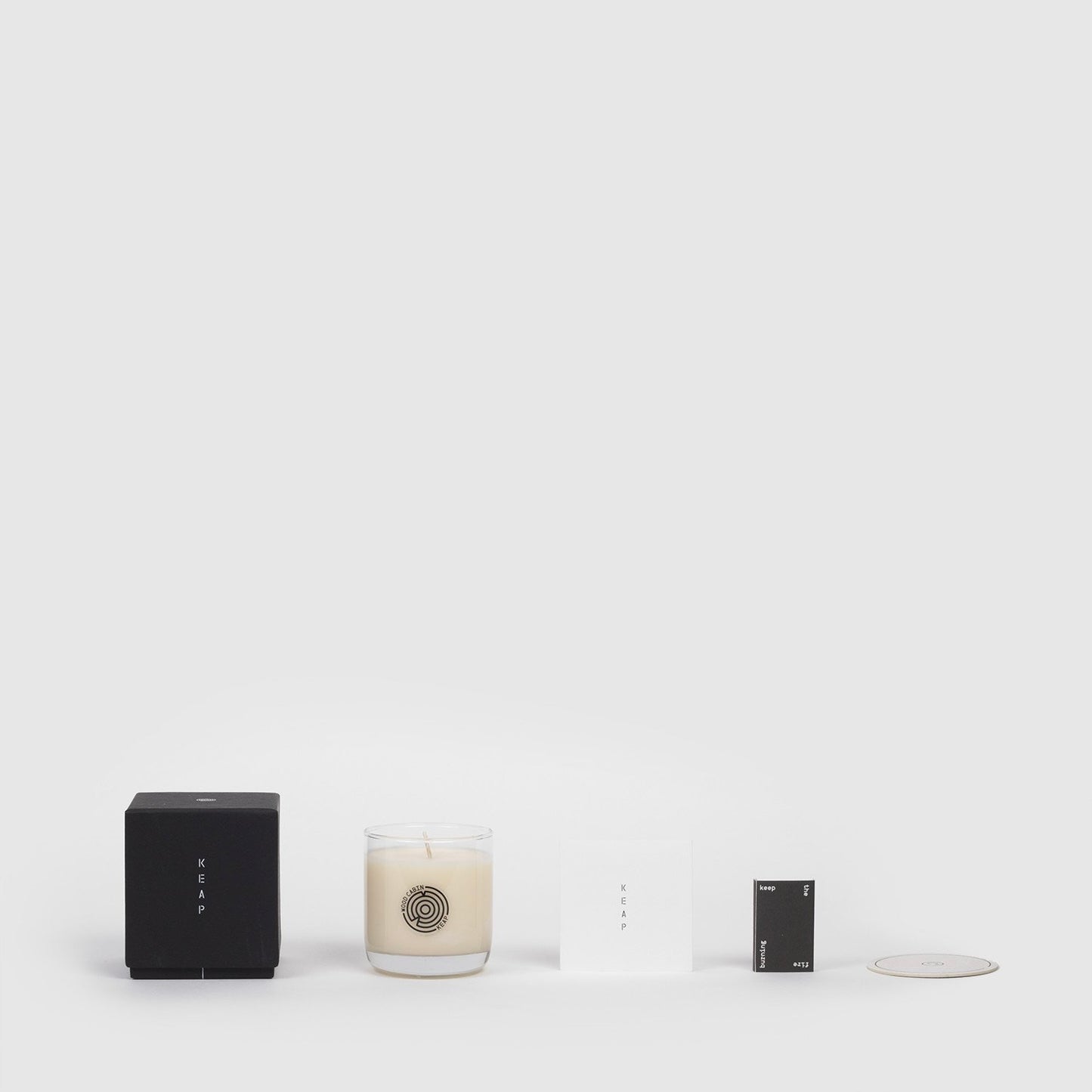 Lifestyle shot of Wood Cabin Scented Candle and the packaging components