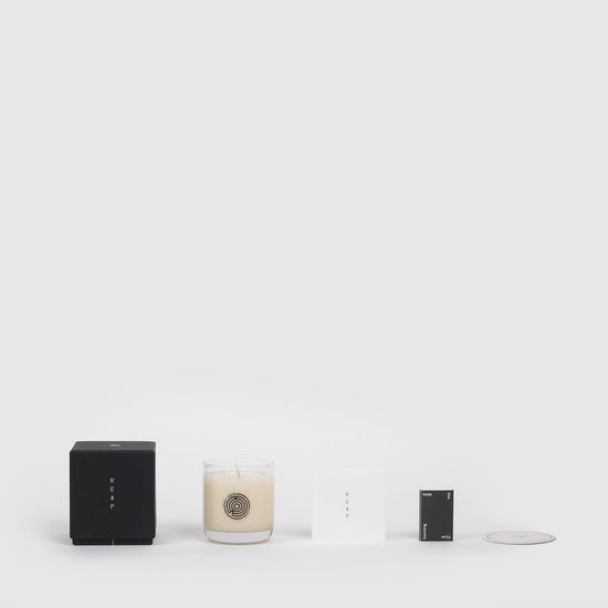 Lifestyle shot of Wood Cabin Scented Candle and the packaging components