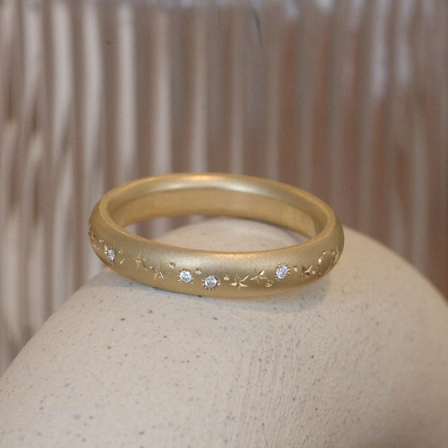 Lifestyle angled view of Celestial Band 4mm / Pave Round Natural Diamonds by Pieces of Starr on a ceramic with a taupe blurred background