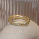 Lifestyle angled view of Celestial Band 4mm / Pave Round Natural Diamonds by Pieces of Starr on a ceramic with a taupe blurred background
