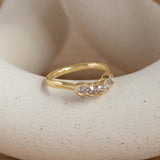 Lifestyle angled side view of Cloud 5 Band Curve / Round Natural Champagne Diamonds / in 14k Yellow Gold by Goldpoint Jewelry on a ceramic with a taupe background