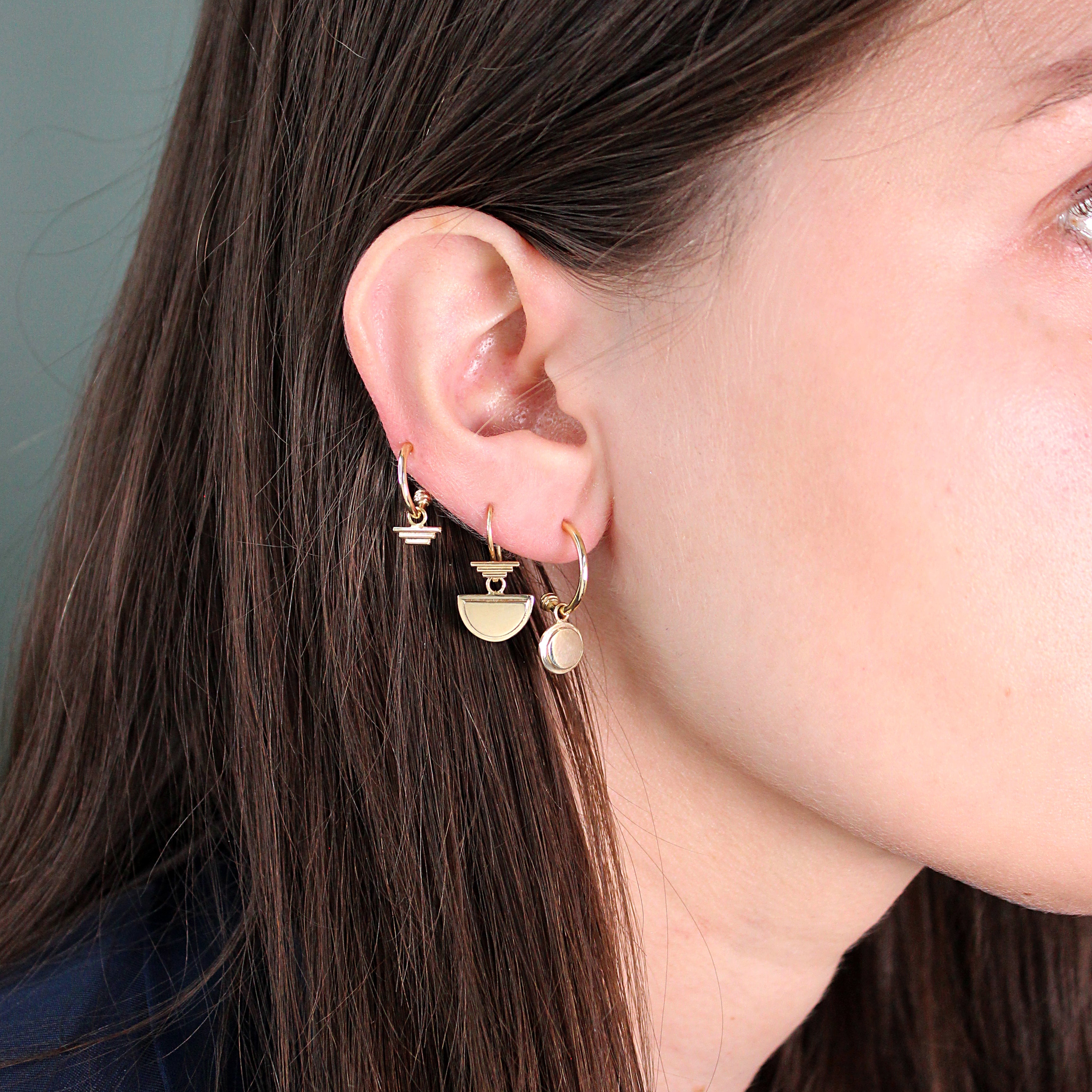 Model wears Step Pyramid Charm on a Cornice Hoop with other earring combinations by Goldpoint Jewelry