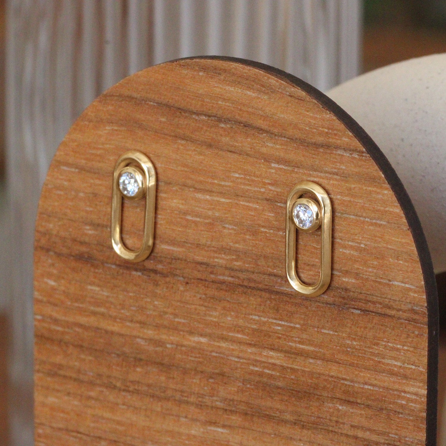 Lifestyle angled side view of Continuum Studs / Round Natural Diamond in 14k yellow gold by Sandy Rubin on a won stand
