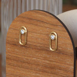 Lifestyle angled side view of Continuum Studs / Round Natural Diamond in 14k yellow gold by Sandy Rubin on a won stand