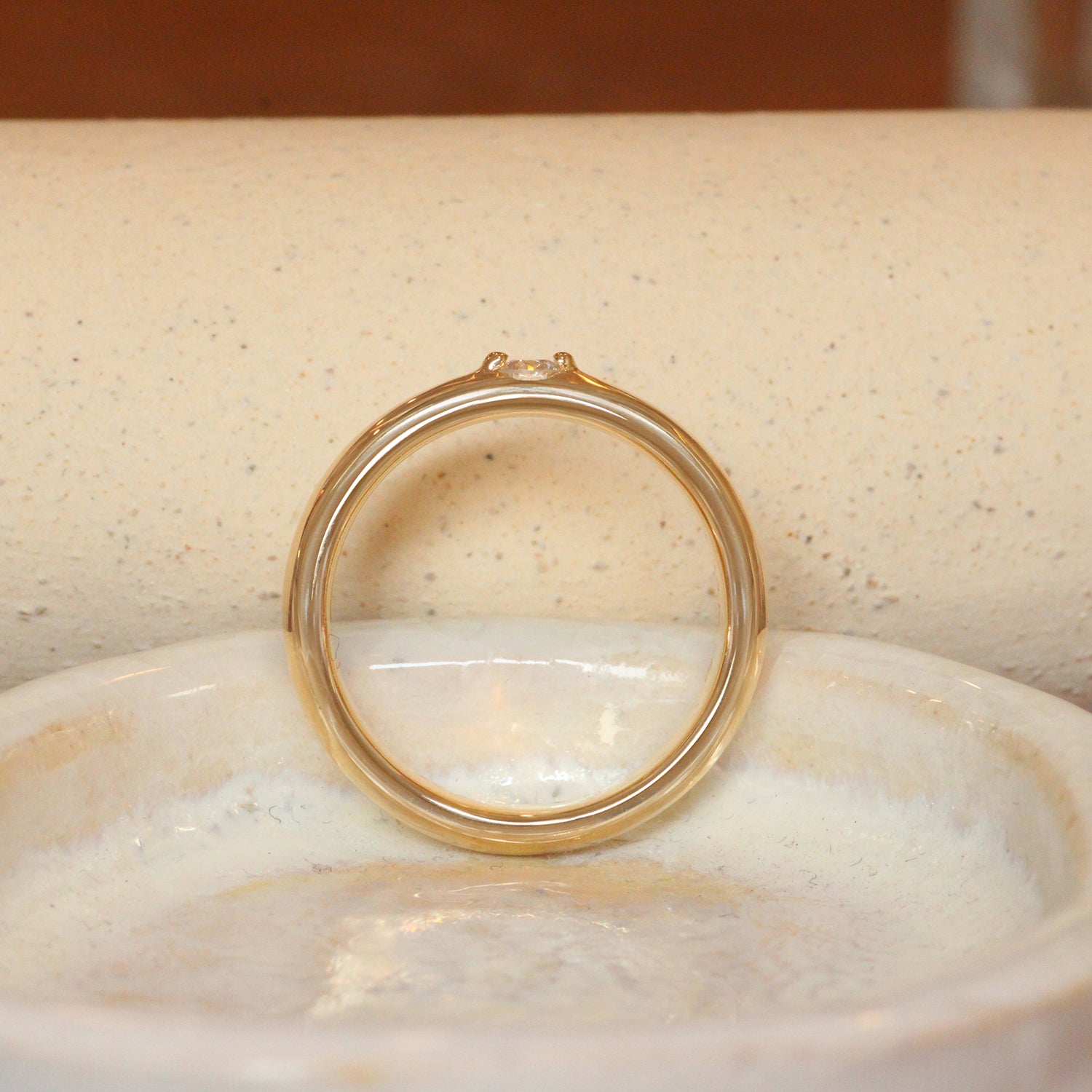 Lifestyle side profile view of Cornice Band Wide / Bead Round Lab Diamond in Yellow Gold by Goldpoint Jewelry on a ceramic