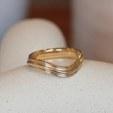 Lifestyle angled view of Cornice Band Deep Curve in 14k yellow gold by Goldpoint Jewelry on a ceramic