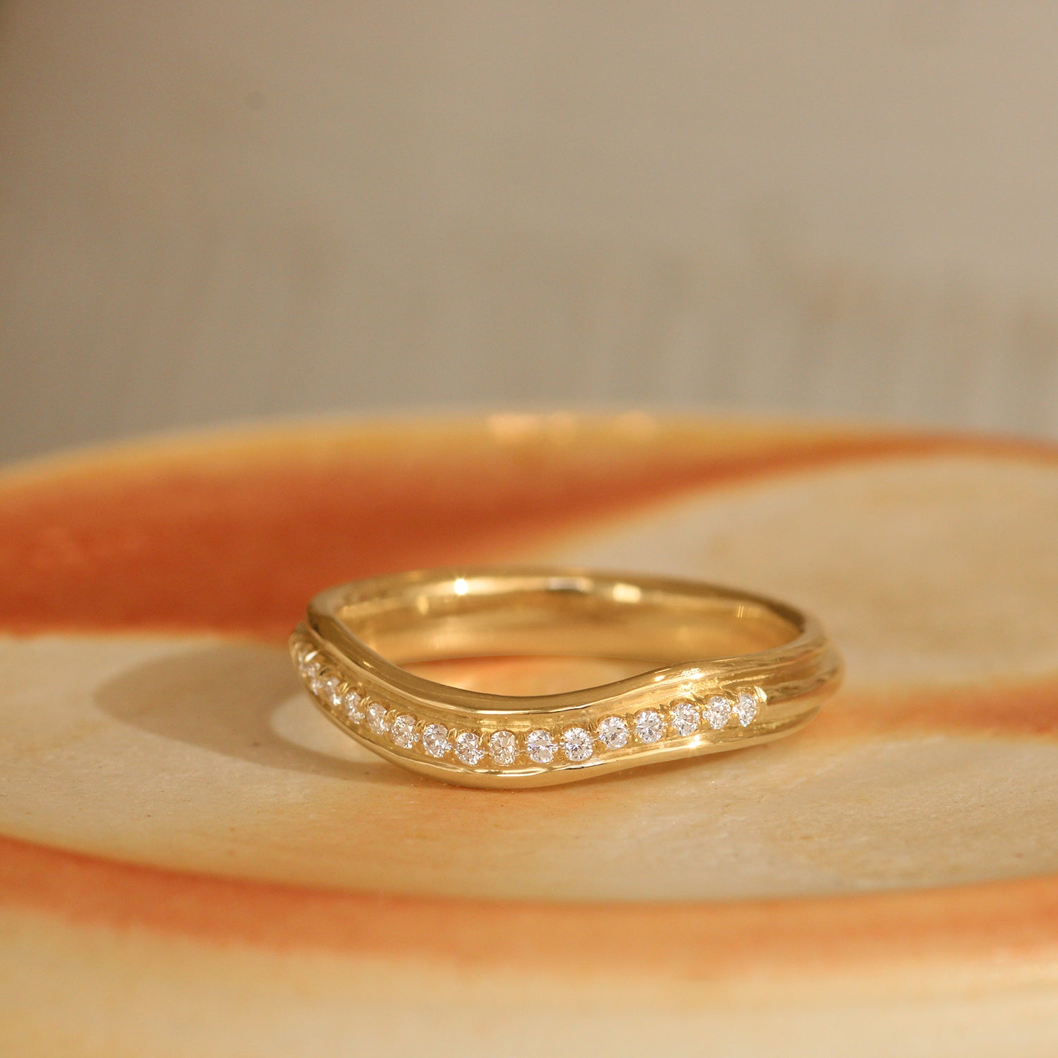 Lifestyle angled view of Cornice Band Soft Curve Pave Round Diamonds in 18k yellow gold