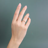 Model wears Dome Band Deep Curve in 14k yellow gold by Goldpoint Jewelry on their ring finger