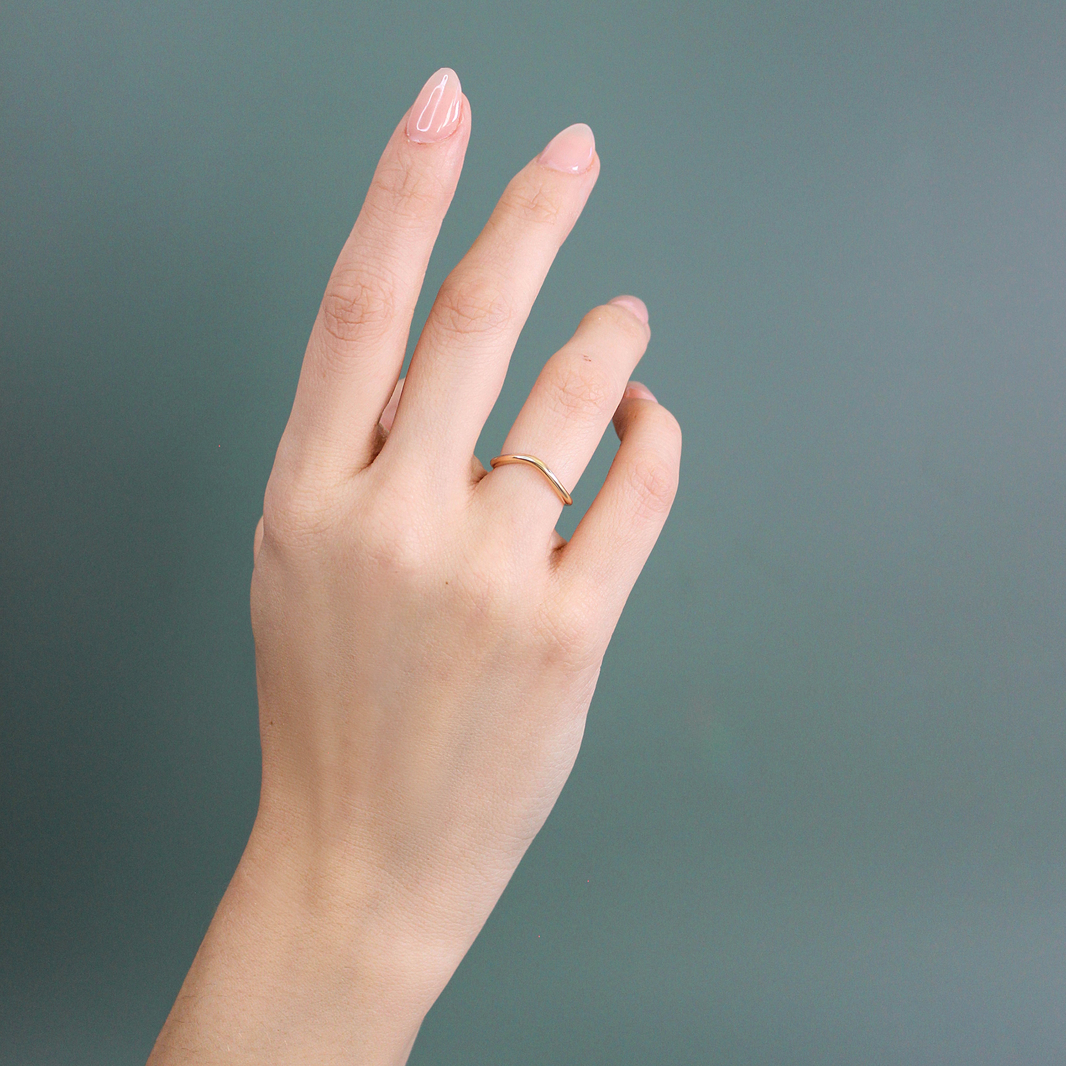 Model wears Dome Band Deep Curve in 14k yellow gold by Goldpoint Jewelry on their ring finger