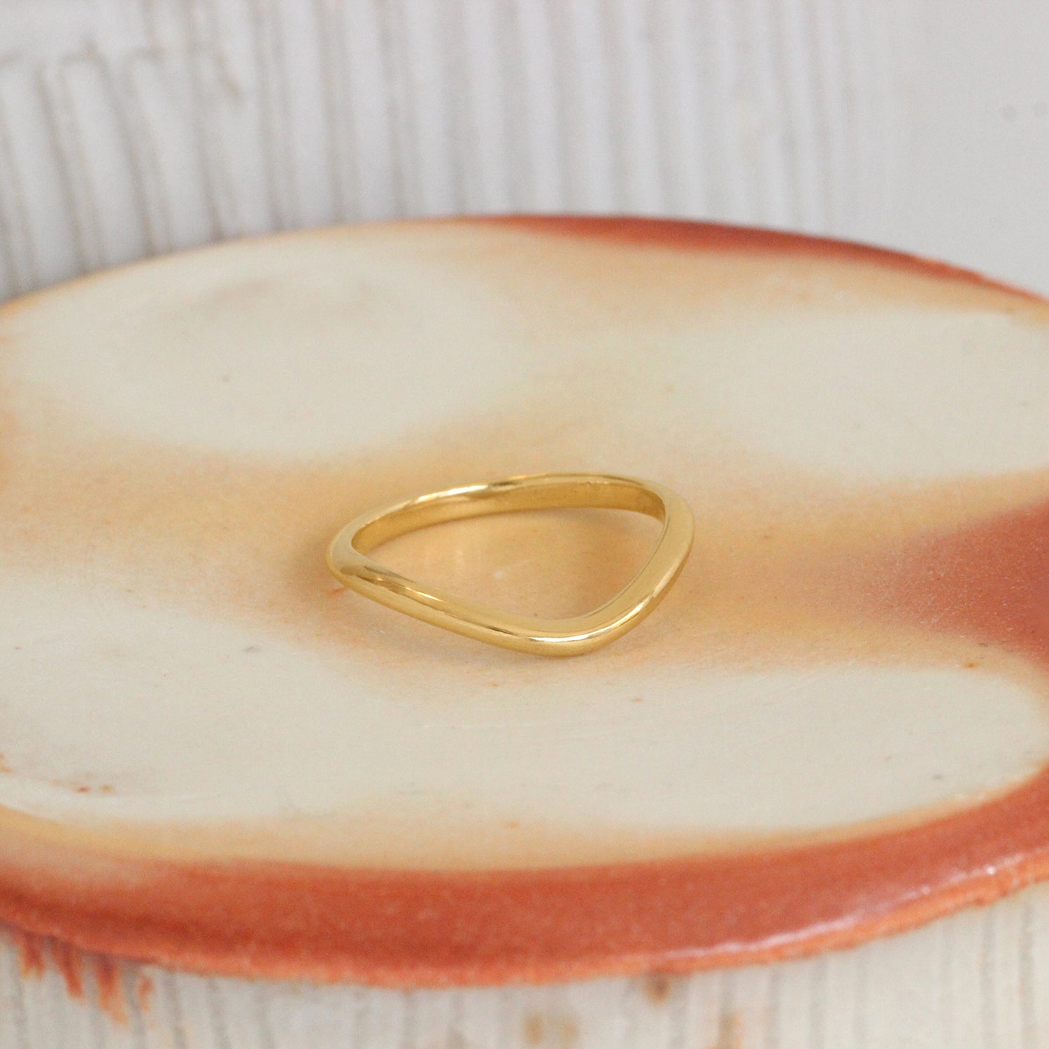 Lifestyle angled view of Dome Band Deep Curve in 14k yellow gold by Goldpoint Jewelry on a ceramic