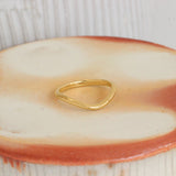Lifestyle angled view of Dome Band Deep Curve in 14k yellow gold by Goldpoint Jewelry on a ceramic