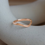 Lifestyle angled view of Dome Band 2mm Deep Curve / in 14k Rose Gold by Goldpoint Jewelry on a ceramic with blurred background