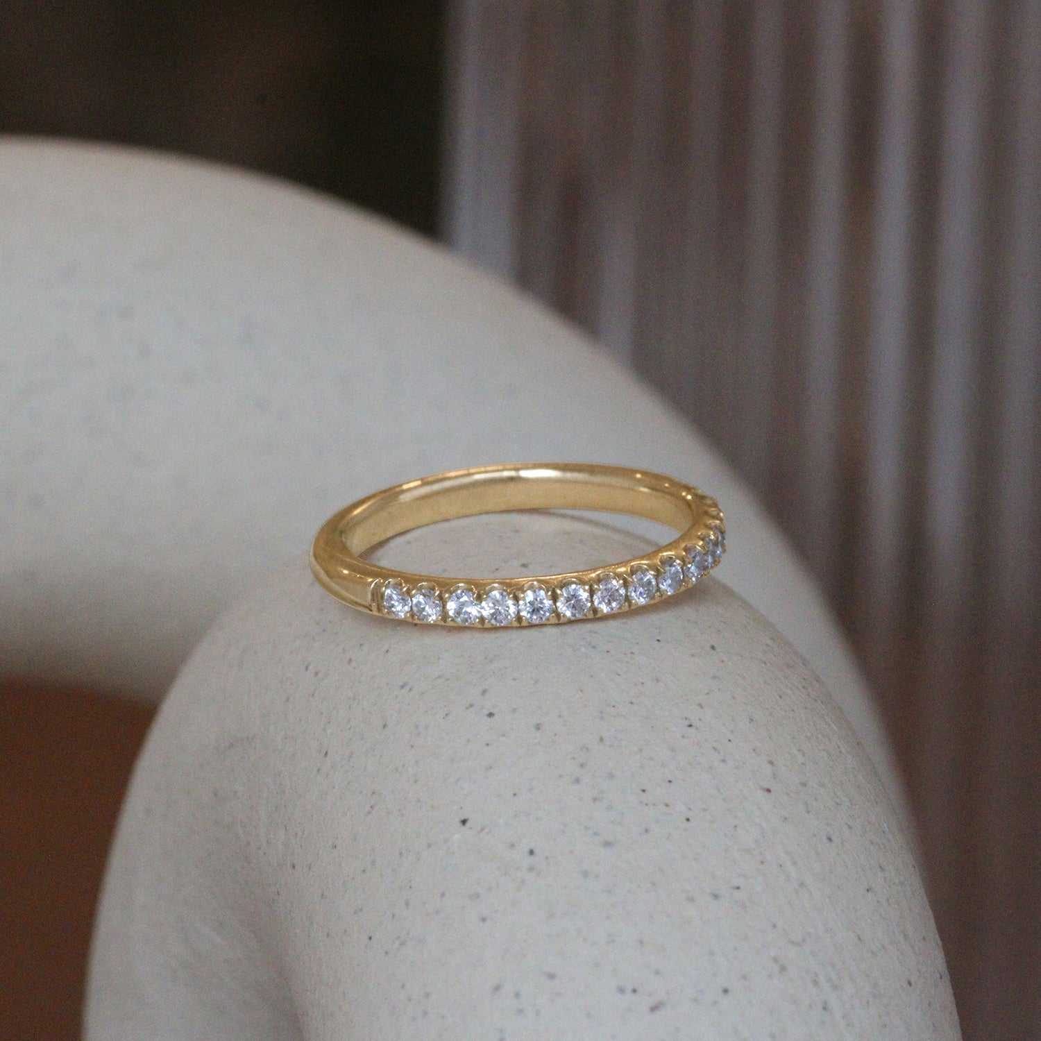 Lifestyle angled view of Dome Band Thick 2mm / Pave Round Natural Diamonds / in 14k Yellow Gold by Goldpoint Jewelry on a ceramic with blurred background
