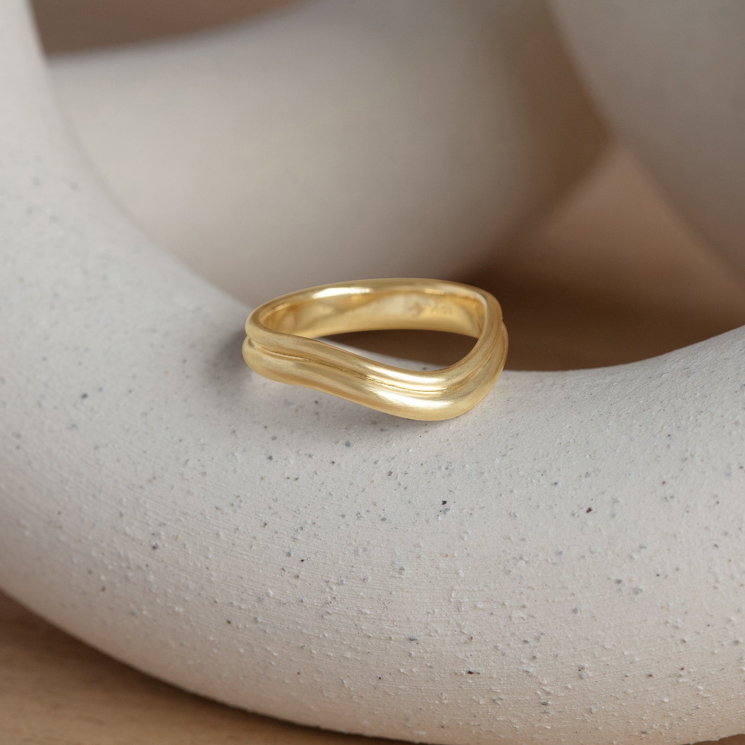 Lifestyle angled view of Duo Band Deep Curve / in Yellow Gold by Goldpoint Jewelry on a ceramic with a natural blurred backdrop