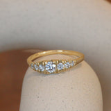 Lifestyle angled view of Grand Pave Diamond Rubidoux Ring / Round Natural Diamond 0.20ct by Erin Cuff on a ceramic with a blurred background