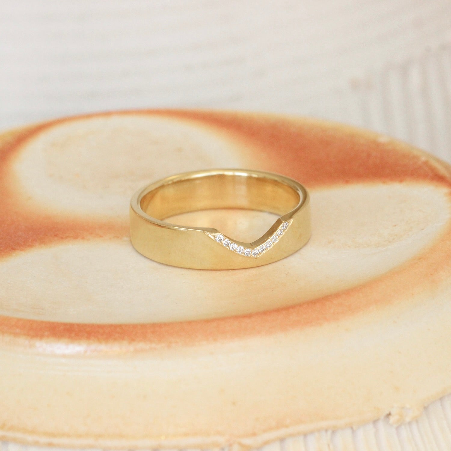 Lifestyle angled shot of Horizon Band Triangle Cutout Pave Round Diamonds in 14k yellow gold