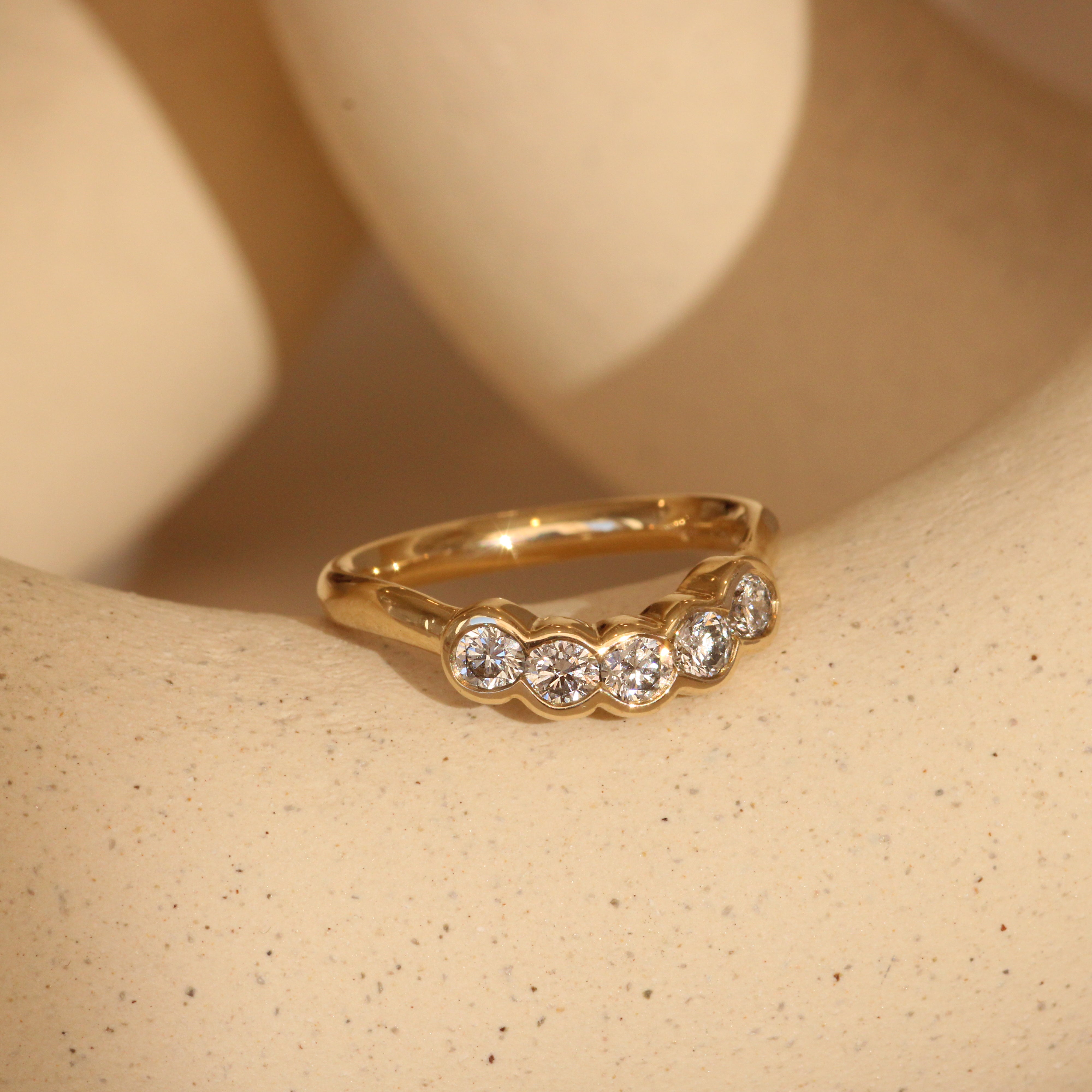 Lifestyle side view of Cloud 5 Band Curve  Round Lab Diamonds in 14k yellow gold
