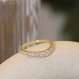 Side view of Keystone Band Soft Curve / Bead Round Diamonds in 14k yellow gold by Goldpoint Jewelry on a ceramic