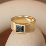Lifestyle angled view of Kingsland Ring Rectangle Cut Sapphire 1.61ct in 14k yellow gold by Goldpoint Jewelry on a ceramic with a blurred background