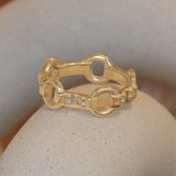 Lifestyle angled view of Lenny Ring by Amour Vee on a ceramic with a blurred background