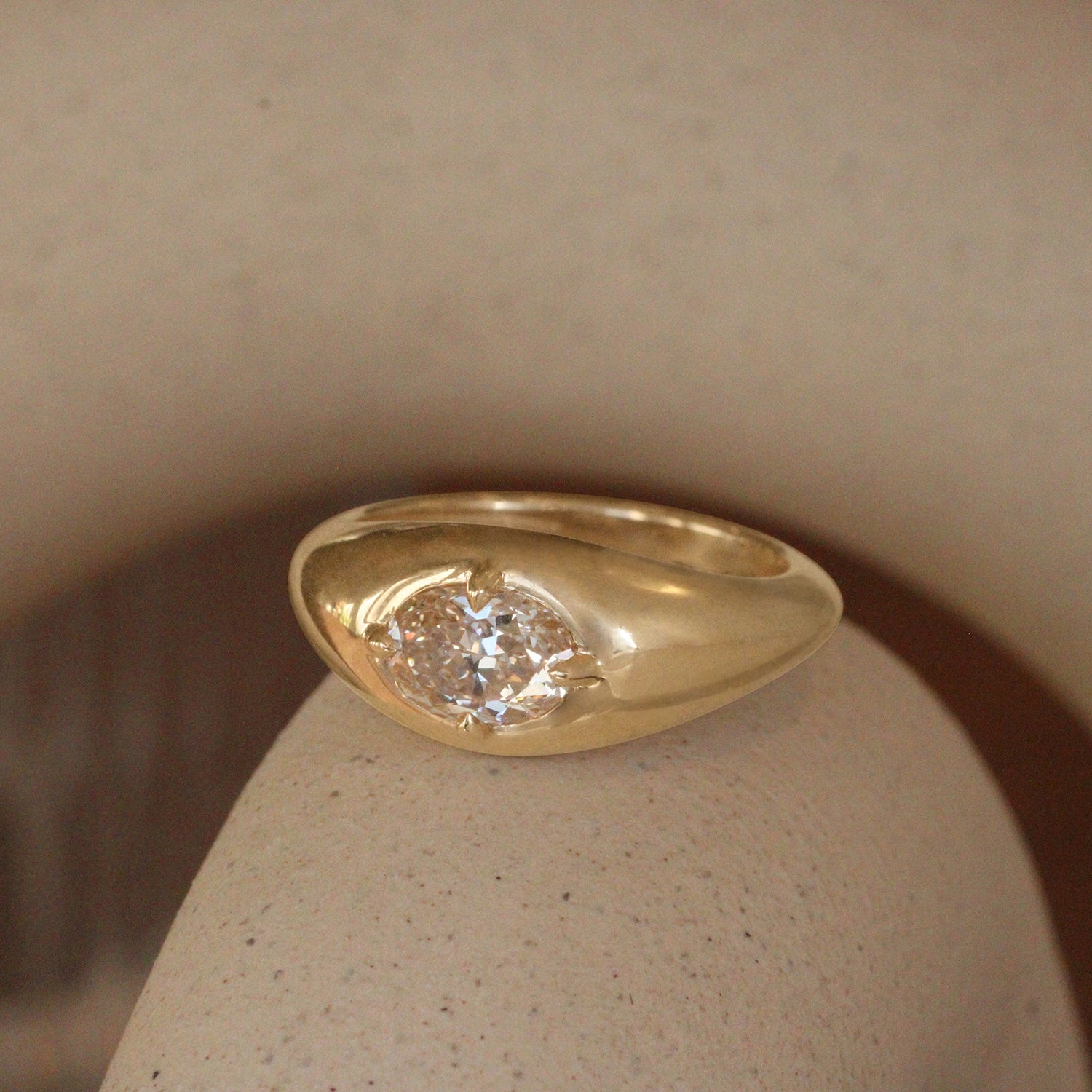 Lifestyle angled view of Leonard 4 Ring Oval Natural Diamond 1.05ct by Goldpoint Jewelry on a ceramic with blurred background