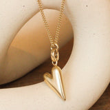 Lifestyle front view of Love You More Charm by Mon Pilar as a necklace hanging over a ceramic