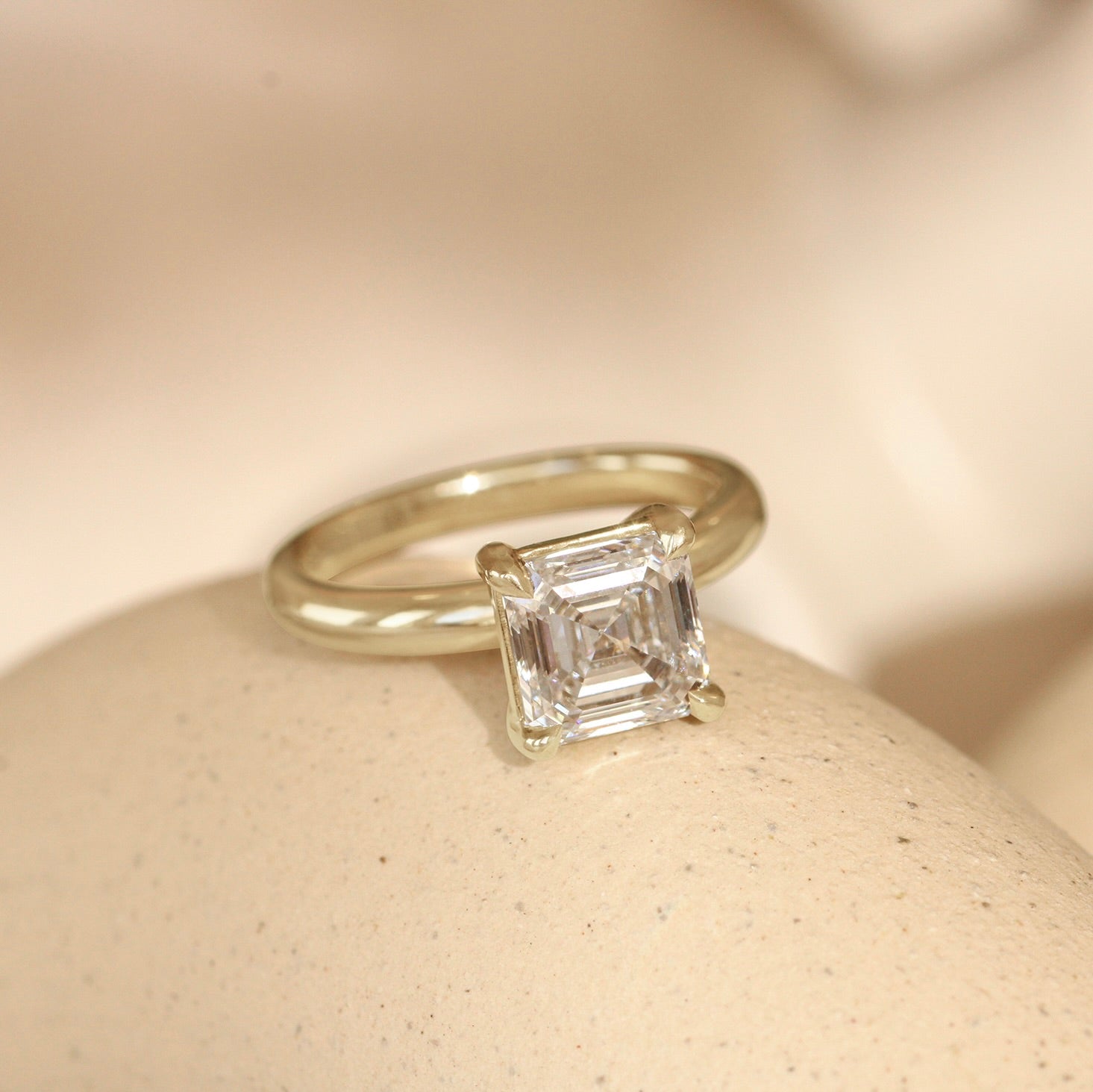 Lifestyle angled view of Noble Ring Asscher Lab Diamond 2.06ct by Goldpoint Jewelry on a ceramic with a blurred background